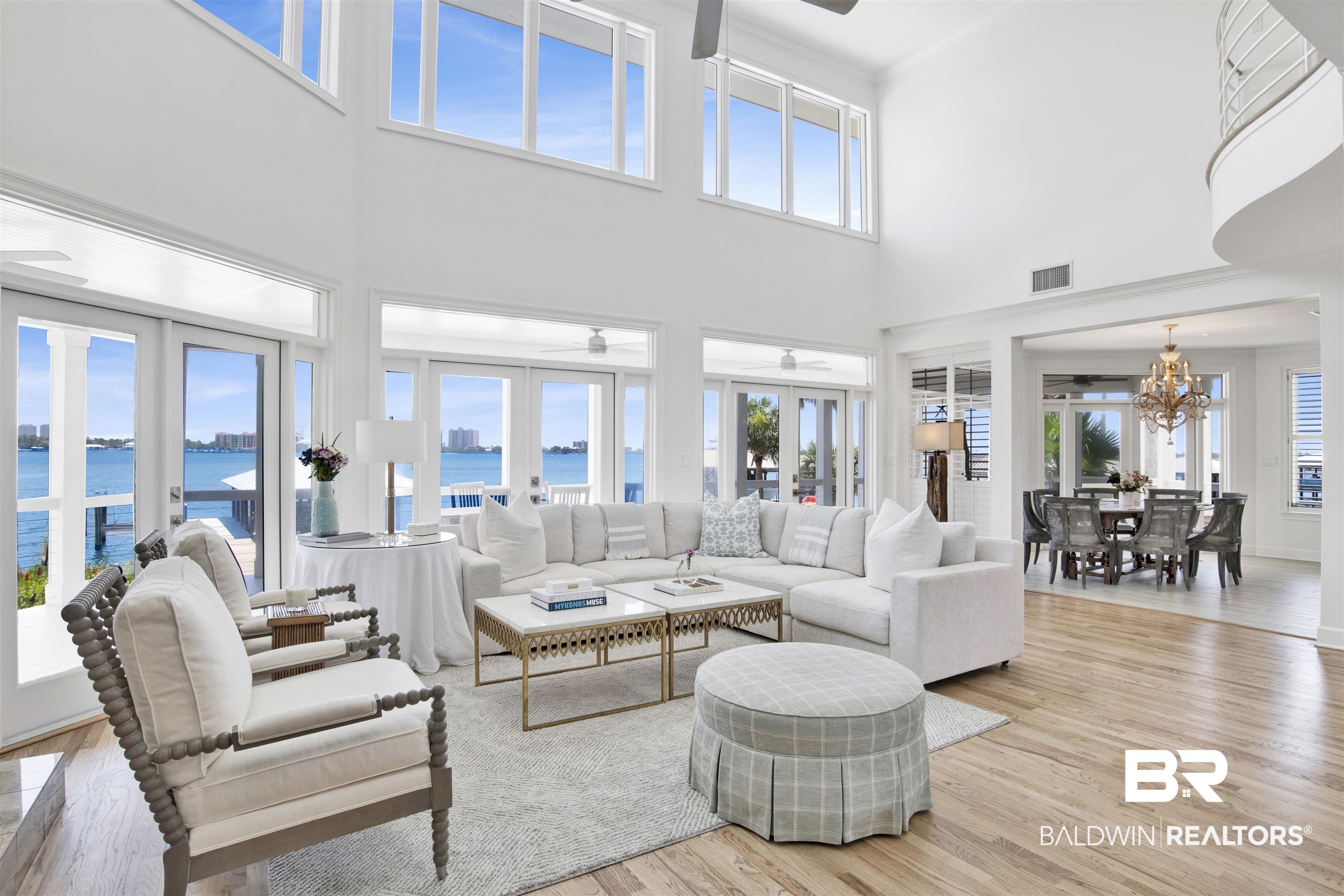 33400 River Road Orange Beach, AL 36561 - Photo 20 of 72 Living room featuring light hardwood / wood-style flooring, french doors, a high ceiling, a water view, and ceiling fan with notable chandelier