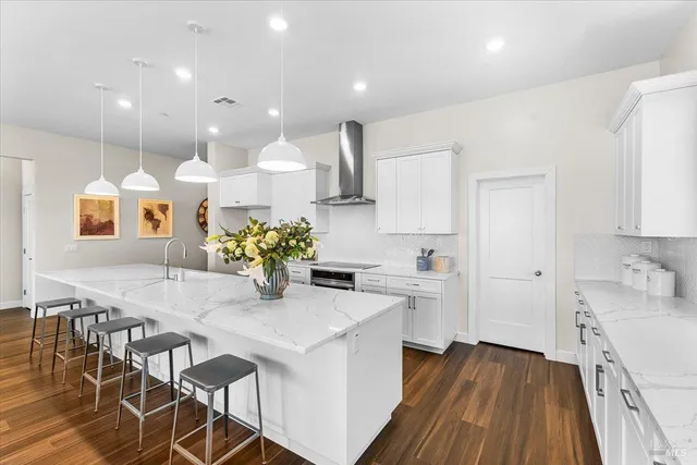 a kitchen with stainless steel appliances kitchen island granite countertop a stove a sink and a refrigerator