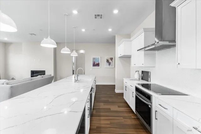 a large white kitchen with stainless steel appliances