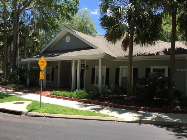 front view of house with a yard and palm trees