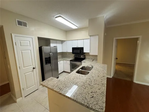 a kitchen with stainless steel appliances granite countertop a refrigerator and a sink
