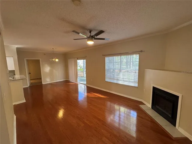 a view of an empty room with window and wooden floor