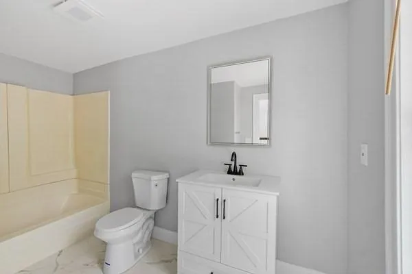 a white toilet sitting next to a bathroom sink
