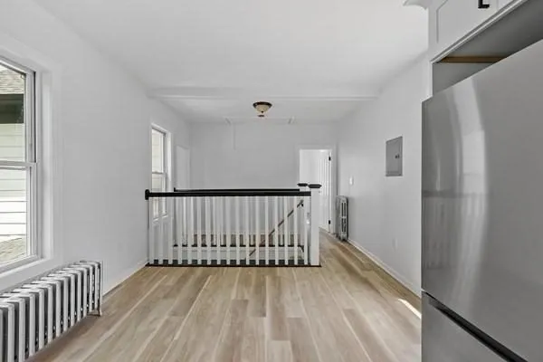 a view of a hallway with wooden floor and entryway