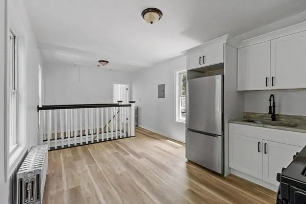 a kitchen with granite countertop a refrigerator and a stove top oven