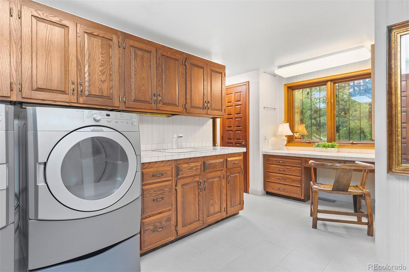 2851 Interlocken Drive Evergreen, CO 80439 - Photo 28 of 50 a kitchen with sink a washer and dryer with wooden floor
