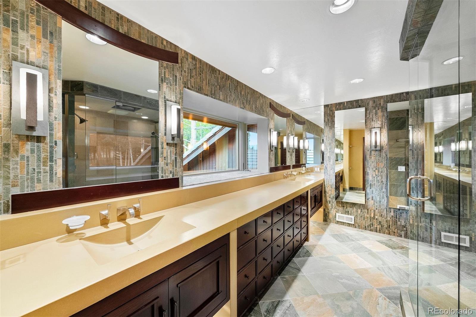 2851 Interlocken Drive Evergreen, CO 80439 - Photo 33 of 50 a bathroom with a sink and a large mirror