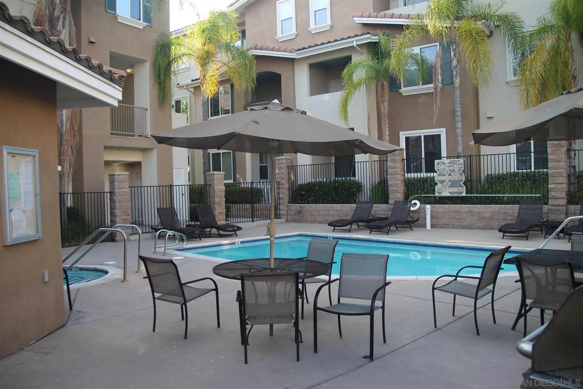 13039 Evening Creek Drive South, Unit 36 San Diego, CA 92128 - Photo 26 of 31 a view of a patio with table and chairs under an umbrella