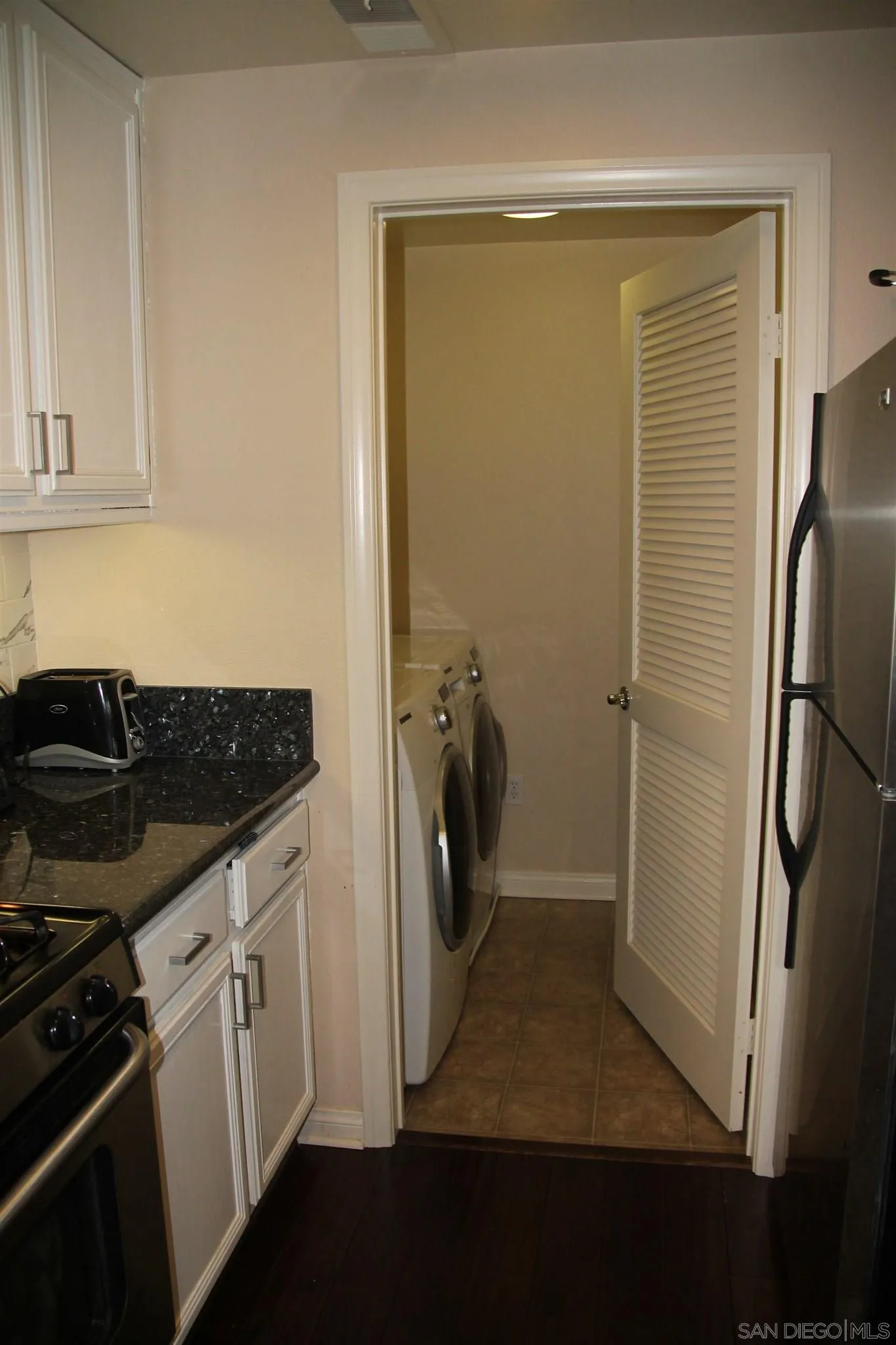 13039 Evening Creek Drive South, Unit 36 San Diego, CA 92128 - Photo 5 of 31 a utility room with cabinets washer and dryer