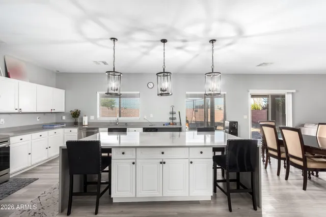 a kitchen with cabinets and chairs