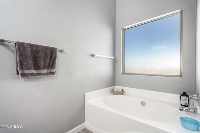 a white bath tub sitting next to a white sink and vanity
