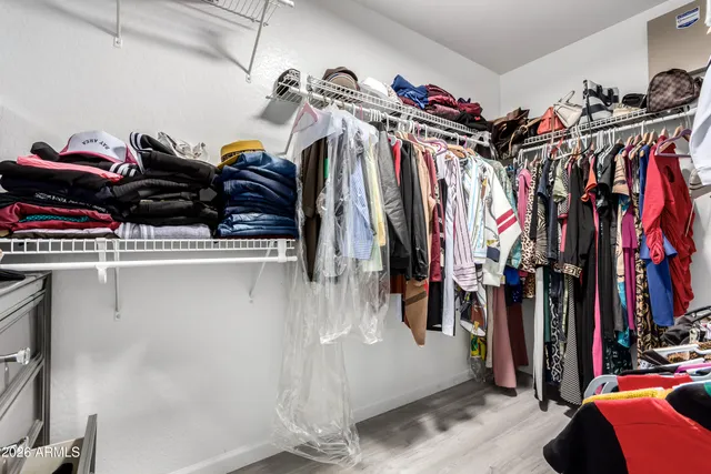 a view of walk in closet with clothes and shoes