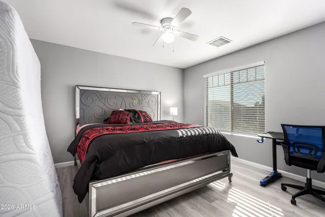 a bedroom with a bed a chair and a chandelier