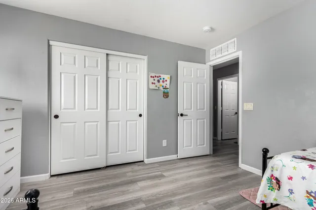 a view of a bedroom with baby bed and closet