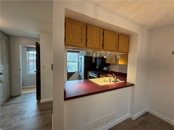 a hallway with white cabinets and wooden floor
