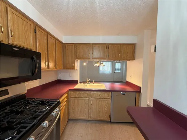 a kitchen with a stove a sink and a microwave