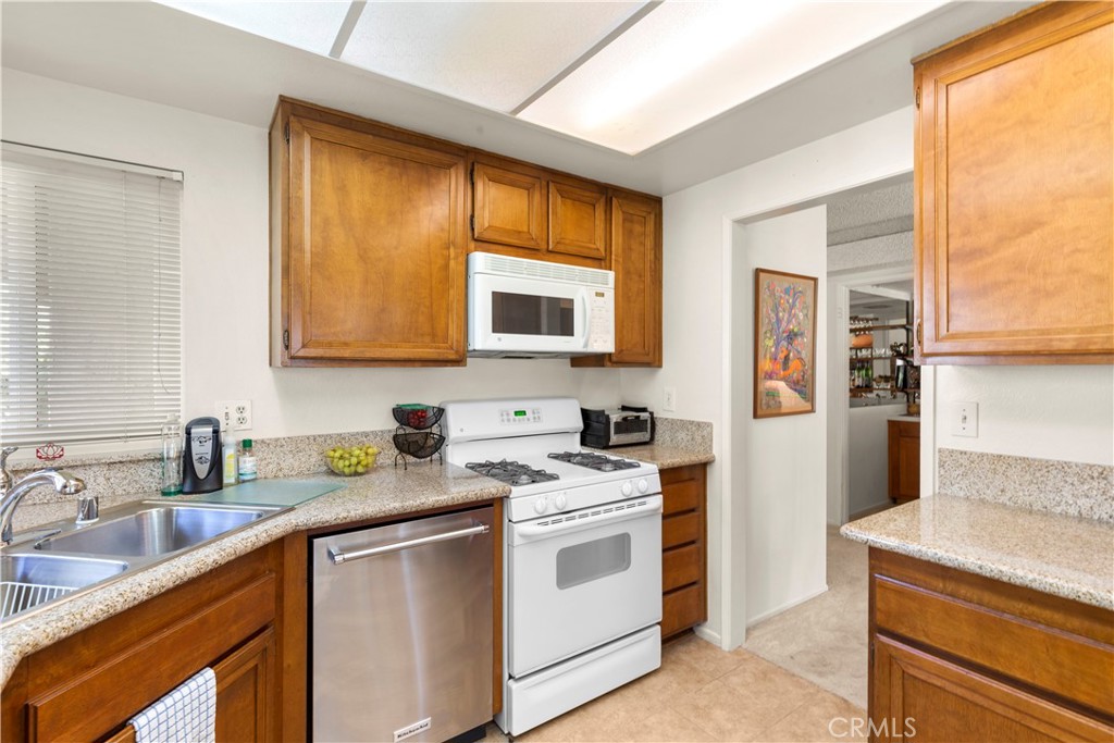 24142 Minnetonka Lane Lake Forest, CA 92630 - Photo 15 of 30 a kitchen with stainless steel appliances granite countertop a stove a sink and a microwave