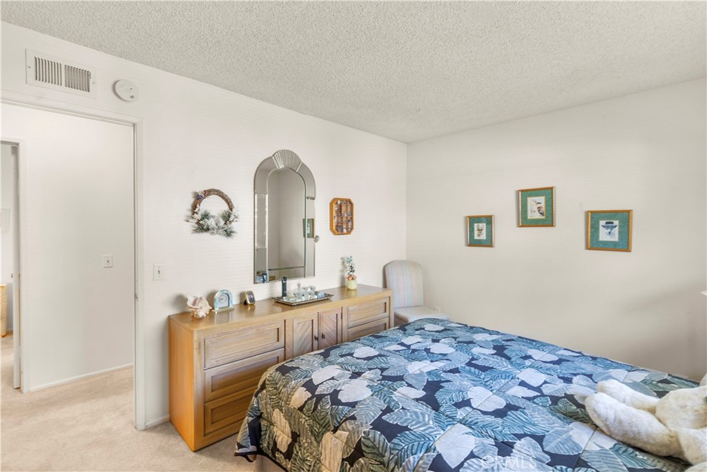 24142 Minnetonka Lane Lake Forest, CA 92630 - Photo 22 of 30 a bedroom with a bed and a chandelier