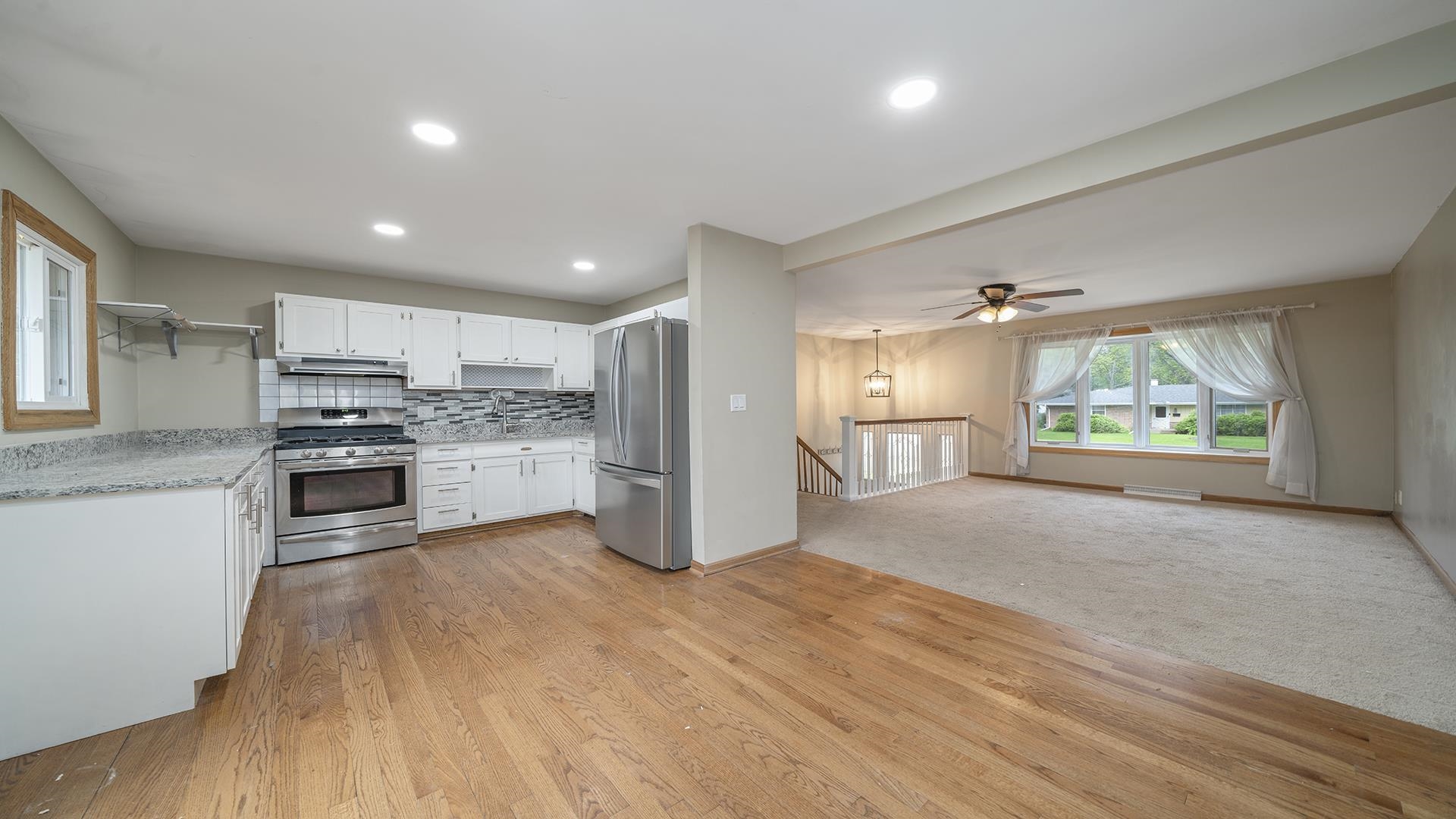 445 Rebecca Road Belvidere, IL 61008 - Photo 18 of 34 a open kitchen with stainless steel appliances granite countertop a refrigerator oven a sink dishwasher and white cabinets with wooden floor
