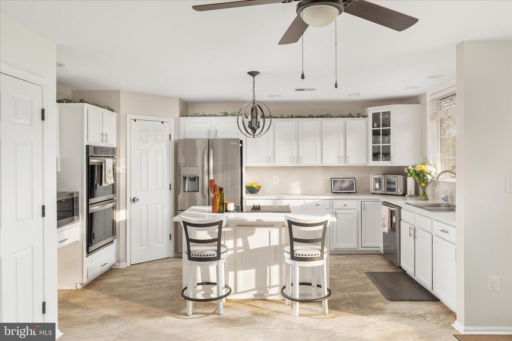 1161 Happy Ridge Drive Front Royal, VA 22630 - Photo 11 of 49 a kitchen with stainless steel appliances kitchen island granite countertop a dining table chairs and white cabinets