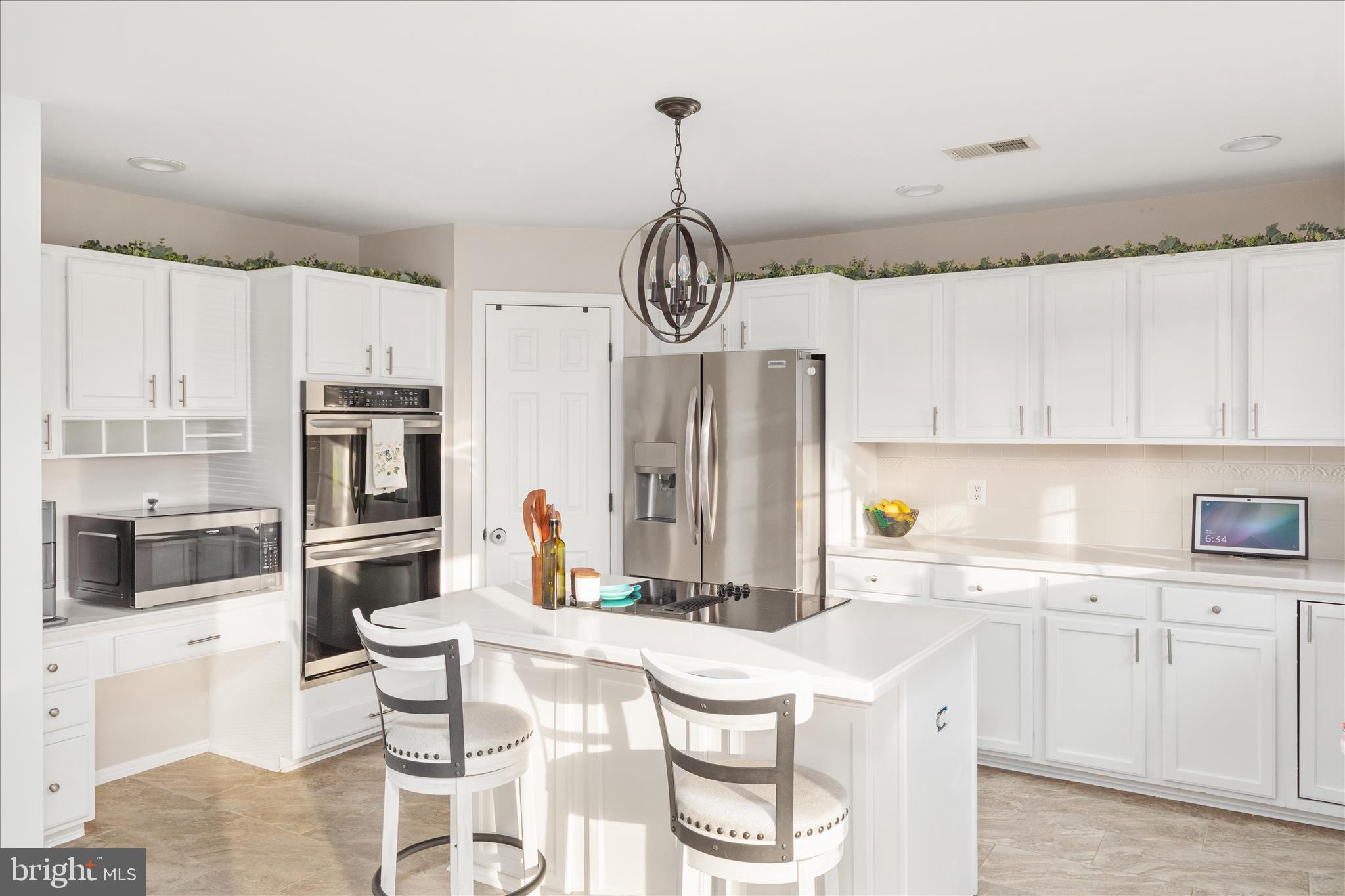 1161 Happy Ridge Drive Front Royal, VA 22630 - Photo 13 of 49 a kitchen with stainless steel appliances granite countertop a stove a sink dishwasher a refrigerator with white cabinets and wooden floor