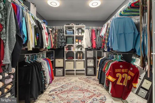 a view of walk in closet with clothes and shoes
