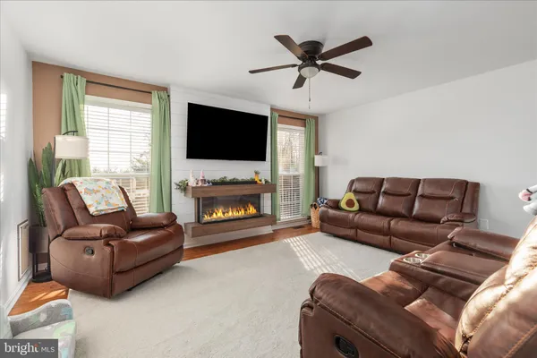 a living room with furniture a flat screen tv and a fireplace