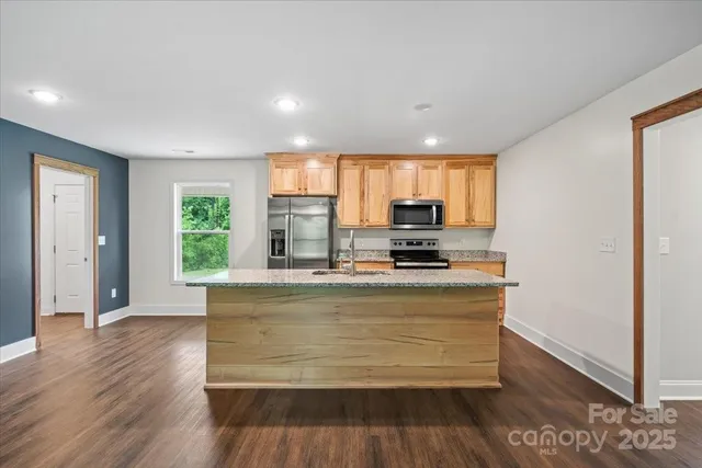 a view of kitchen with wooden floor and electronic appliances