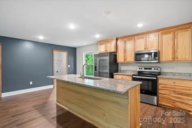 a kitchen with kitchen island granite countertop appliances and a counter space