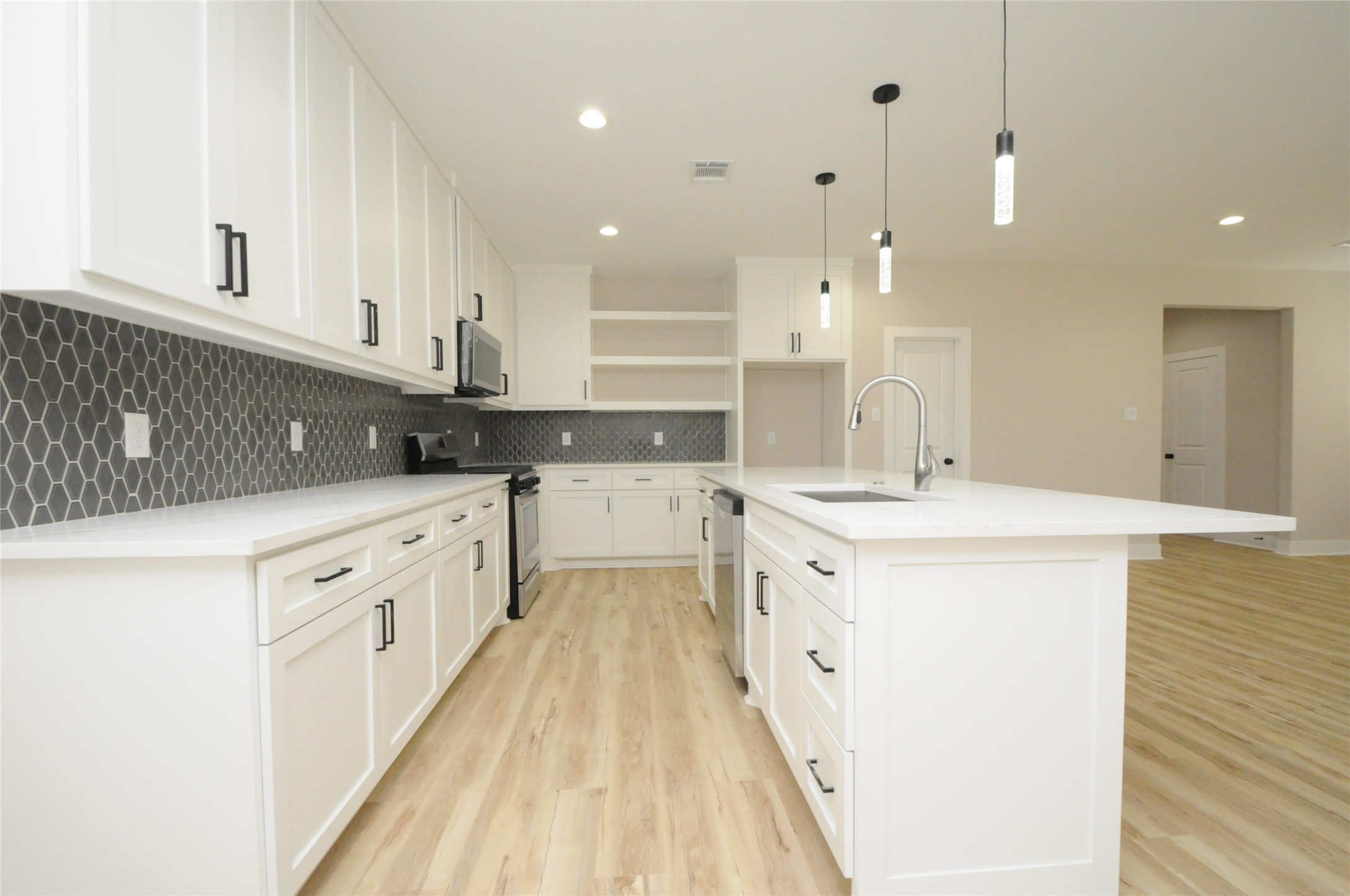 8203 Gladstone Street Houston, TX 77051 - Photo 11 of 41 a kitchen with a sink a counter top space stainless steel appliances and cabinets