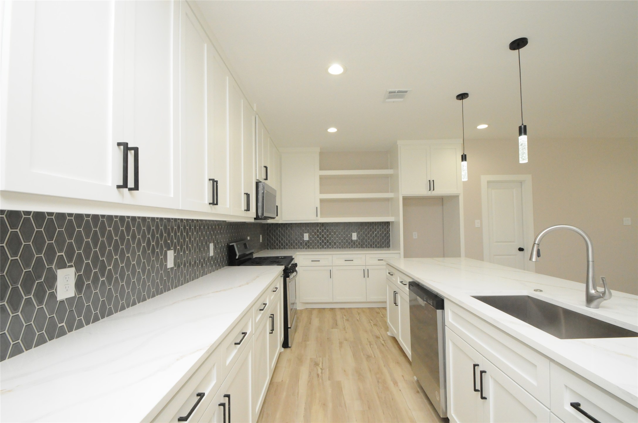 8203 Gladstone Street Houston, TX 77051 - Photo 12 of 41 a kitchen with a sink a stove and cabinets
