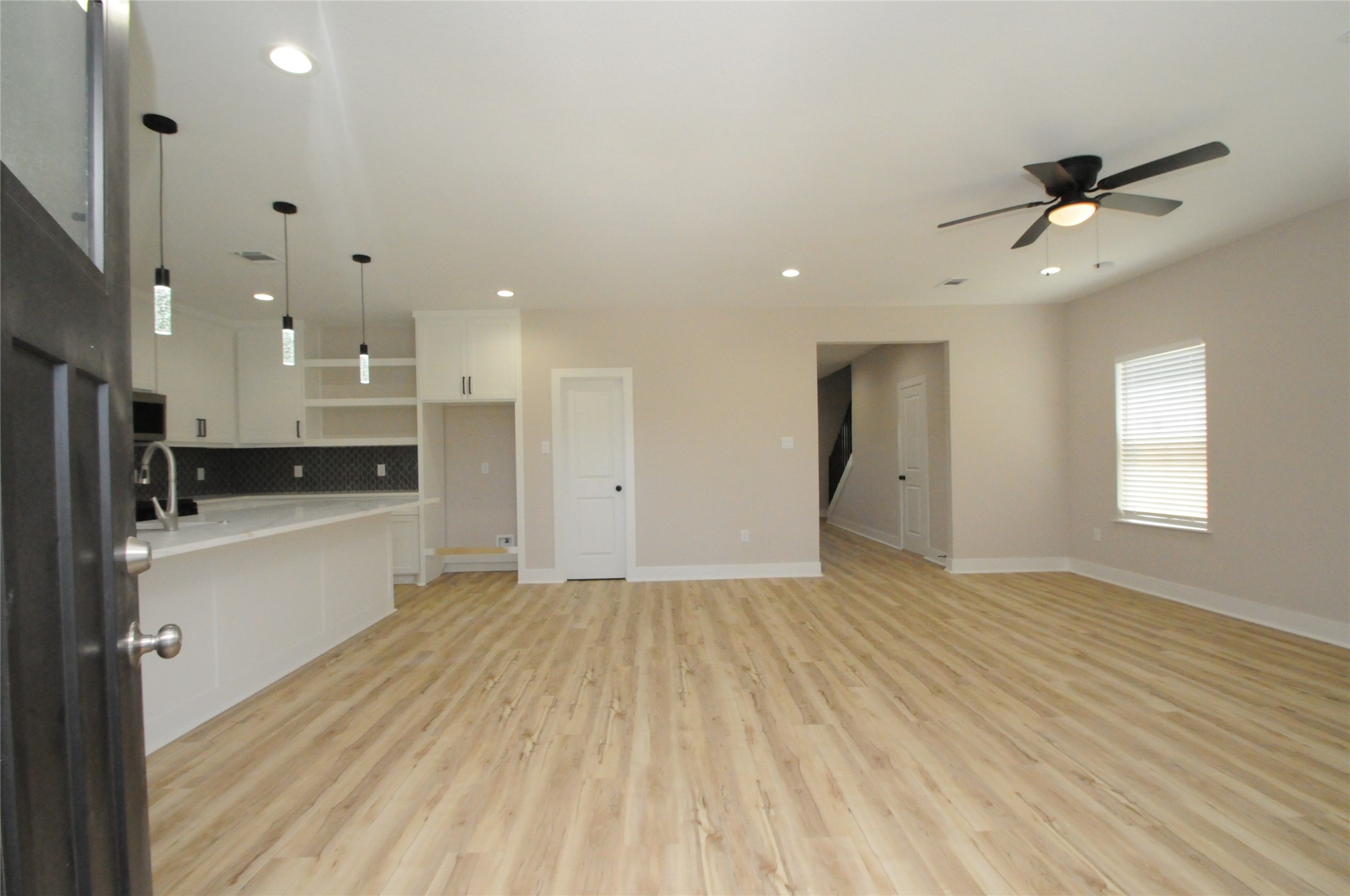 8203 Gladstone Street Houston, TX 77051 - Photo 2 of 41 a view of an empty room and kitchen with wooden floor