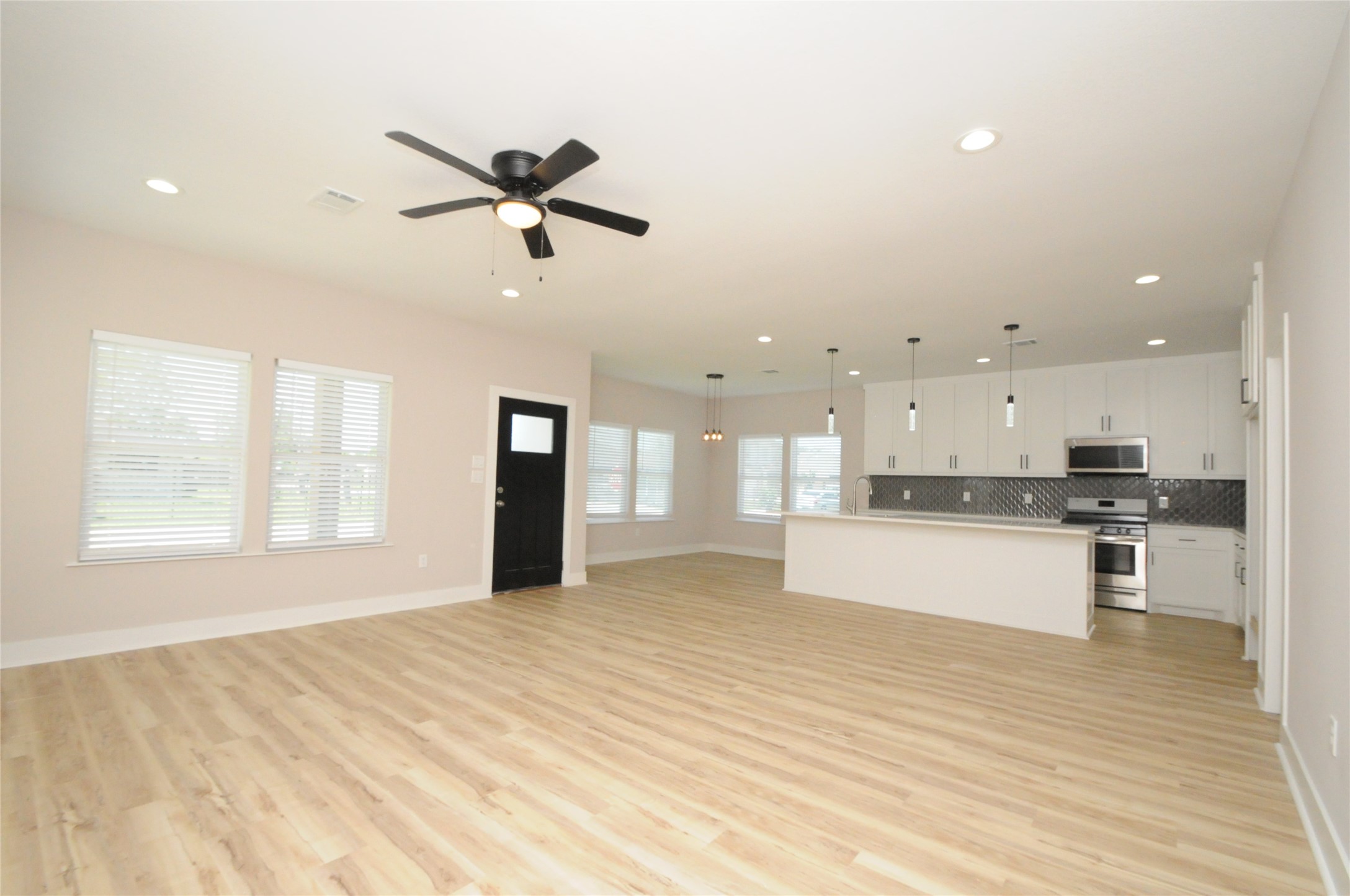 8203 Gladstone Street Houston, TX 77051 - Photo 5 of 41 a view of kitchen with kitchen island white cabinetry and wooden floor