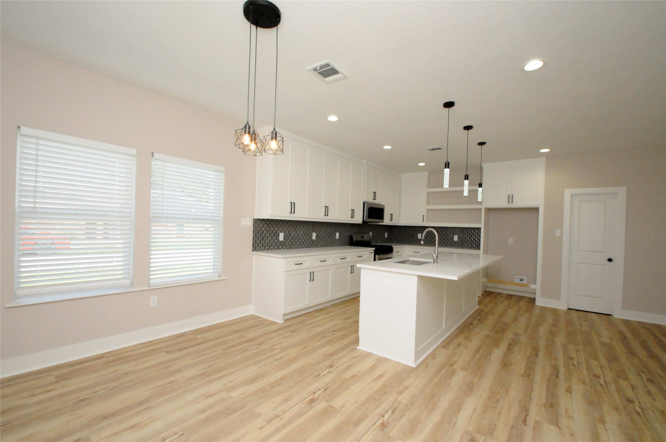 8203 Gladstone Street Houston, TX 77051 - Photo 7 of 41 a kitchen with kitchen island a sink a stove and a window