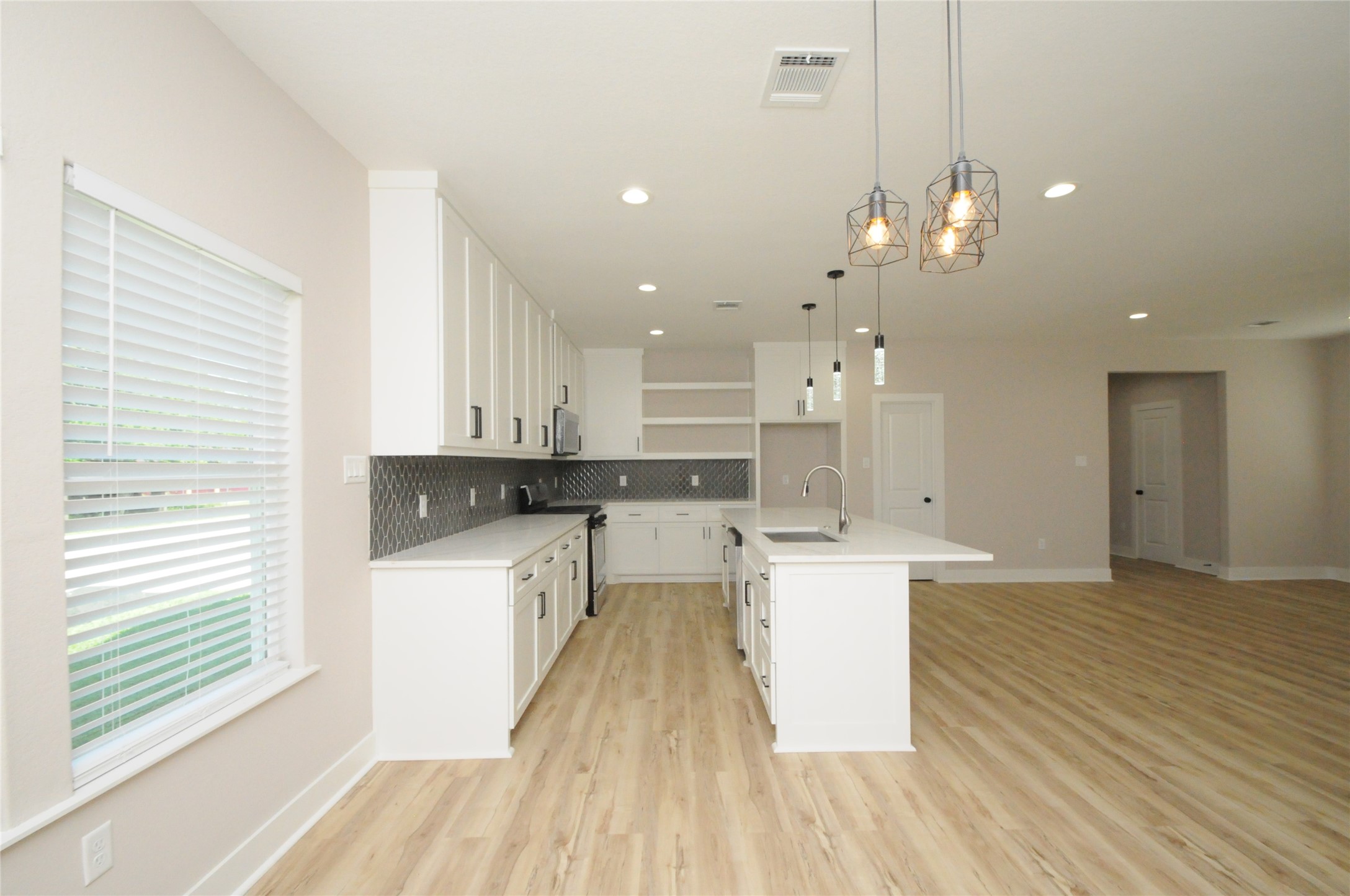 8203 Gladstone Street Houston, TX 77051 - Photo 8 of 41 a large kitchen with cabinets wooden floor and stainless steel appliances