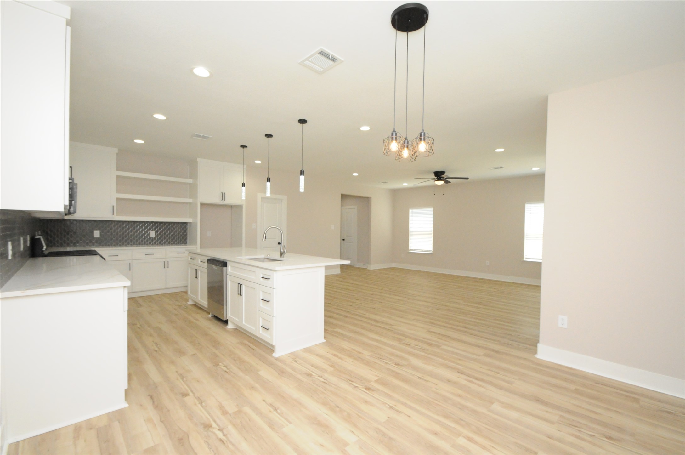 8203 Gladstone Street Houston, TX 77051 - Photo 10 of 41 a open kitchen with white cabinets and wooden floor