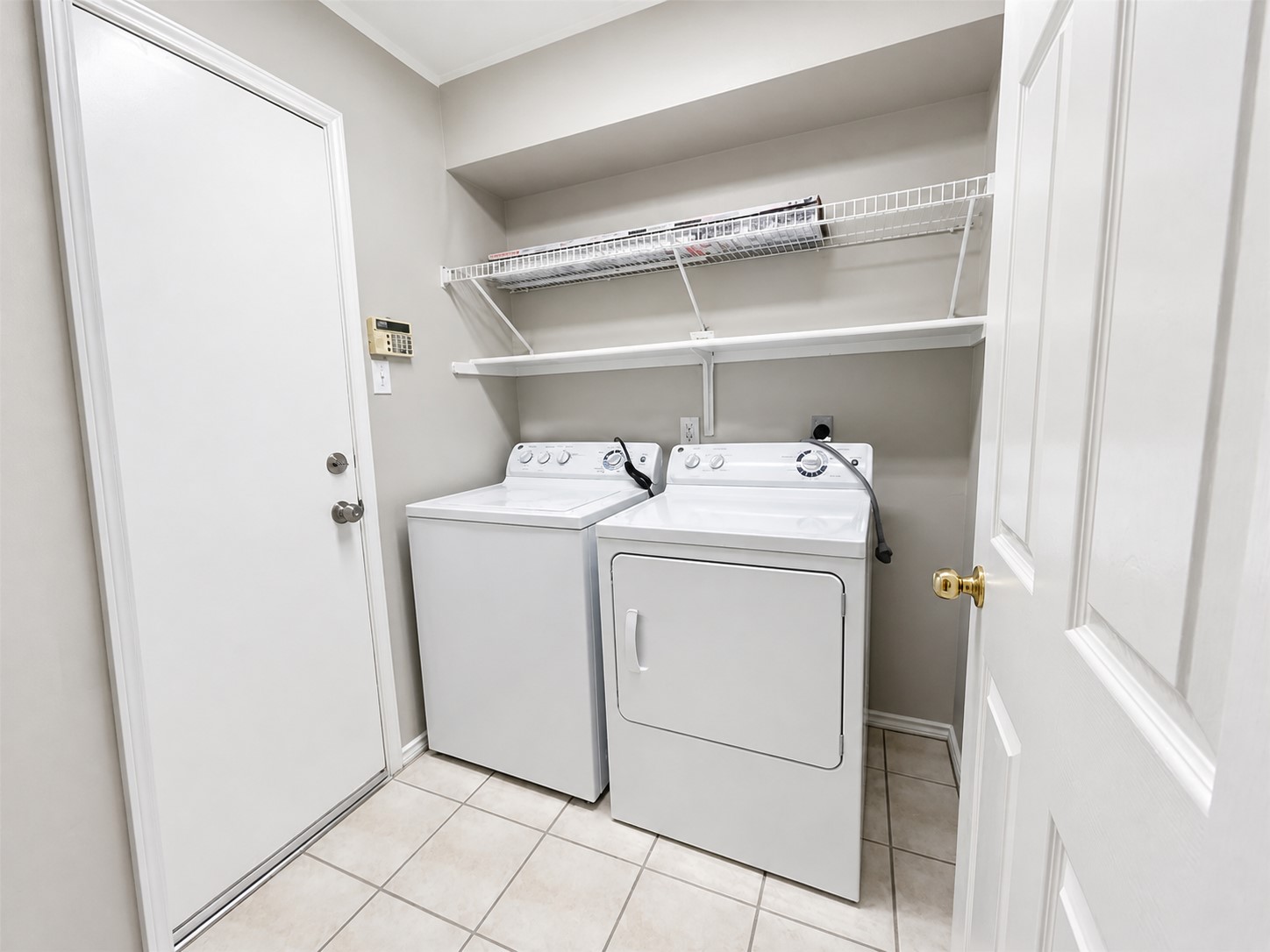 14828 Single Trace Austin, TX 78728 - Photo 23 of 30 Laundry area featuring tile flooring, white walls, and a built-in wire shelving system