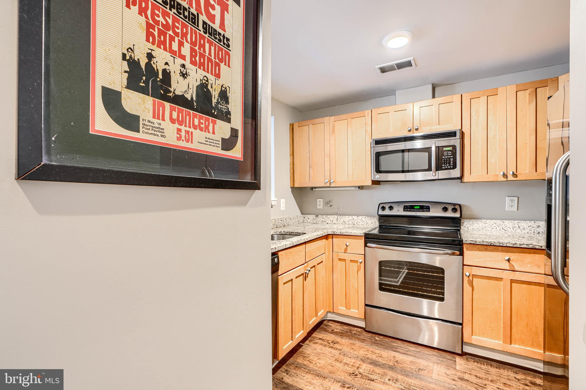 123 West Barre Street, Unit 103 Baltimore, MD 21201 - Photo 3 of 26 a kitchen with stainless steel appliances granite countertop a stove top oven microwave and sink
