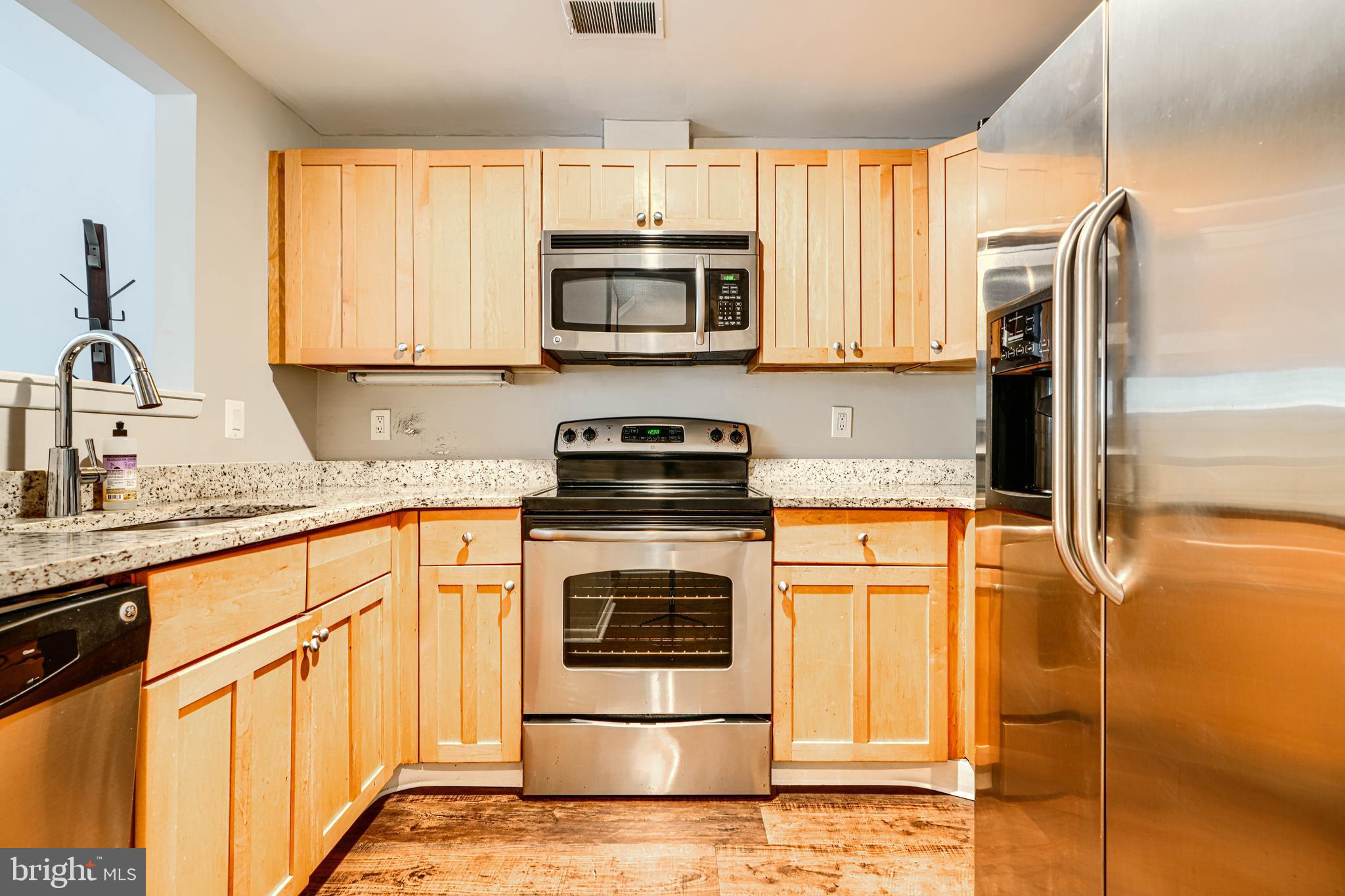 123 West Barre Street, Unit 103 Baltimore, MD 21201 - Photo 4 of 26 a kitchen with stainless steel appliances granite countertop a stove a sink and a microwave