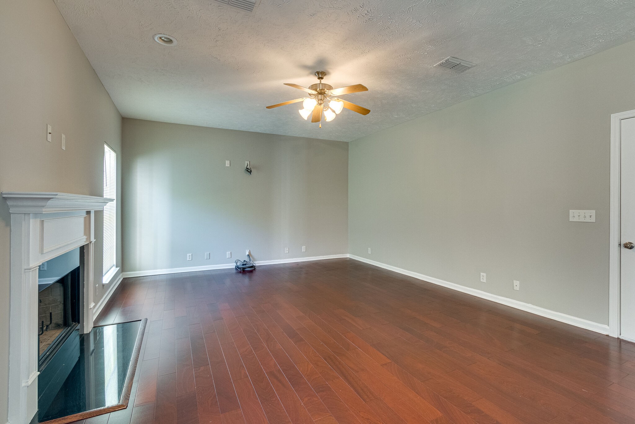 611 Buck Cherry Way Murfreesboro, TN 37128 - Photo 11 of 36 a view of an empty room with wooden floor and a fireplace