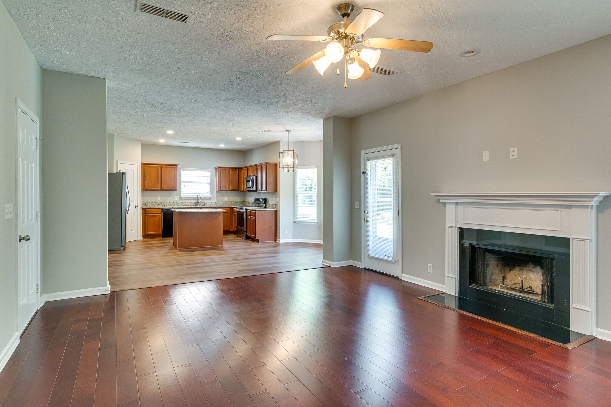 611 Buck Cherry Way Murfreesboro, TN 37128 - Photo 12 of 36 a view of a room with wooden floor and a kitchen