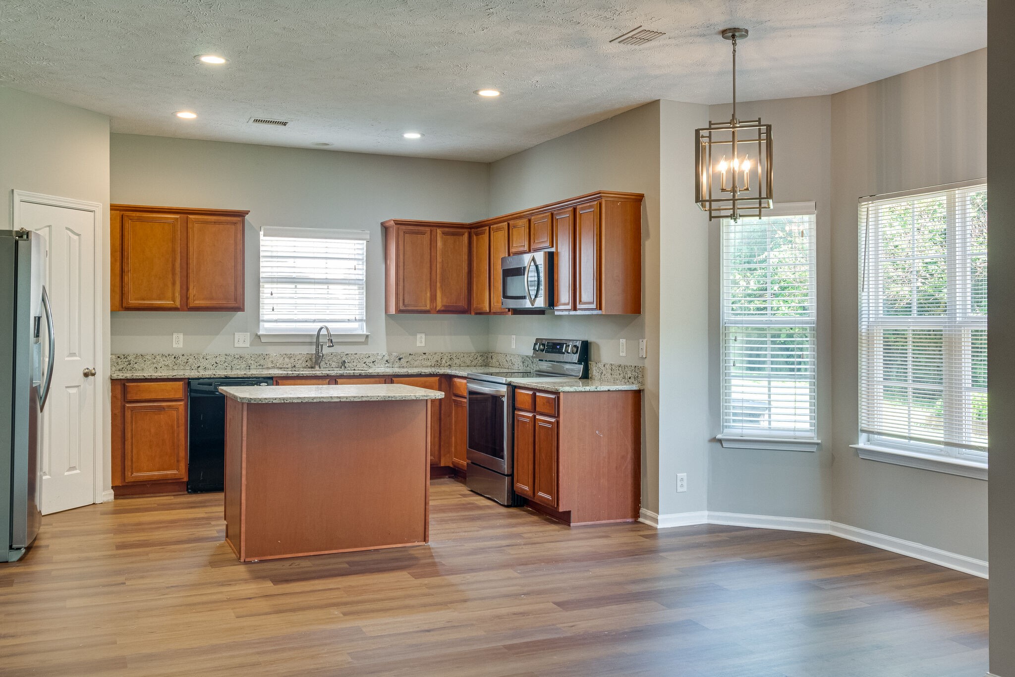611 Buck Cherry Way Murfreesboro, TN 37128 - Photo 13 of 36 a kitchen with granite countertop wooden floors a sink cabinets and appliances