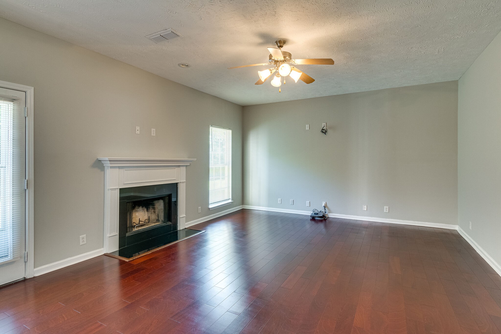 611 Buck Cherry Way Murfreesboro, TN 37128 - Photo 10 of 36 a view of an empty room with wooden floor and fireplace