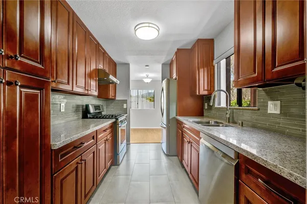 a kitchen with stainless steel appliances granite countertop a stove top oven a sink and dishwasher