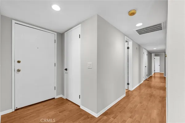 a view of a hallway with wooden floor