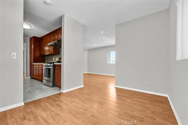 a view of kitchen with kitchen island a sink wooden floor and stainless steel appliances