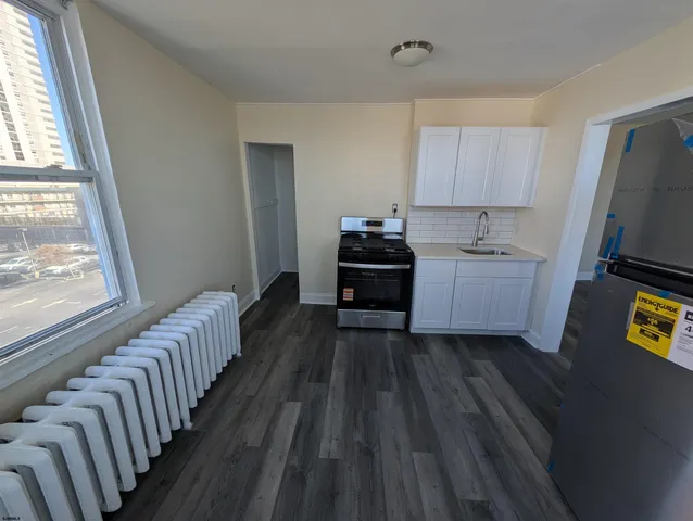 a kitchen with wooden floors and windows