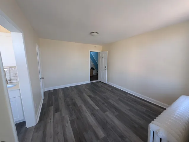 a view of a room with wooden floor
