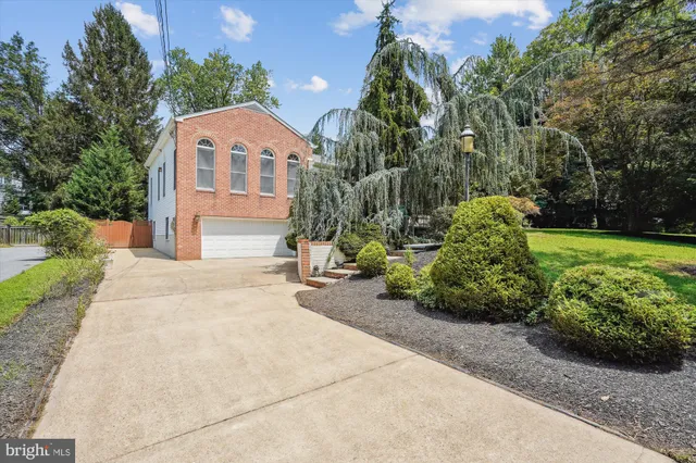 a front view of a house with a yard and potted plants