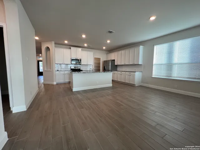 a large kitchen with large windows and wooden floors